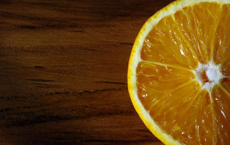 A sweet orange on the teak wood table. Macro photography.の写真素材