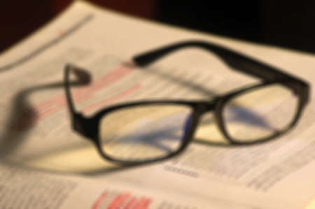 Defocused abstract background of black glasses on a bookの写真素材