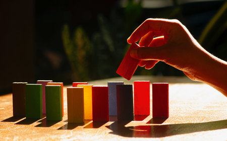 Colorful wooden toys, educational logic toys for kids with childrenâ€™s hand close up,...