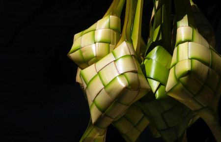 Ketupat Lebaran, a rice cake packed inside a diamond shaped container of woven coconut leaves,...