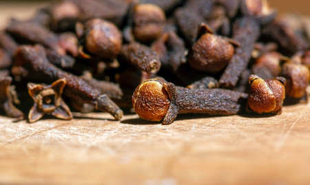Dried clove seeds, in shallow focus, on the wooden table.の写真素材