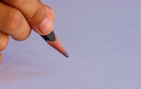 Writing with a black pencil, selected focus, isolated on white background. Education concept