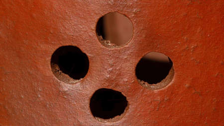 Earthenware handmade clay texture  with holes for backgroundの写真素材