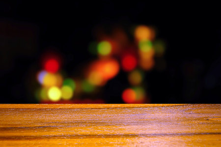 Wooden board empty table in front of colorful bokeh light in the nightの写真素材