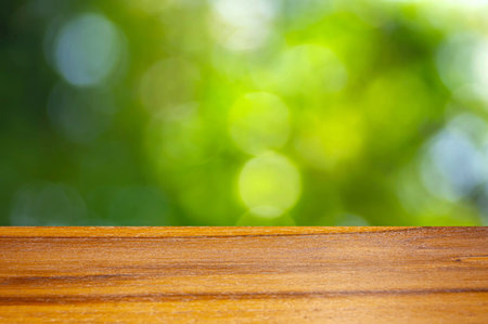 Wooden board empty table in front of green bokeh background for display of productの写真素材