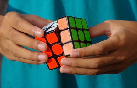 A child playing a colorful rubik cube puzzleのeditorial素材