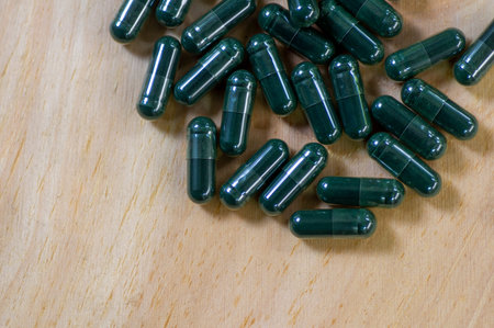 Close up of green medicine capsules, Spirulina, in shallow focus