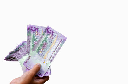 Asian children hand with five Riyal, the currency of Saudi Arabia, concept of charity, giving, Eid...