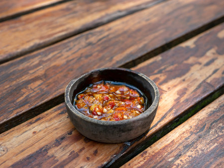 Sambal Bawang, spicy onion sauce, traditional chili sauce from Indonesia, on wooden table.の写真素材