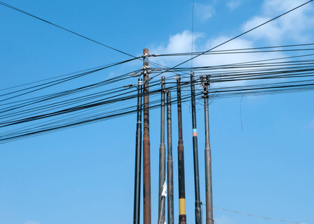 Many fiber internet communication cables on poles in Yogyakarta, Indonesia, with blue sky...