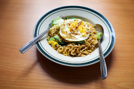 Mie Goreng Telor, Indonesian traditional street food, fried noodles with egg cooked with spices typical of Javanese cuisine.の写真素材