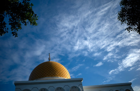 Kubah Masjid. A mosque with a beautiful yellow dome in Yogyakarta, Indonesia with blue sky...