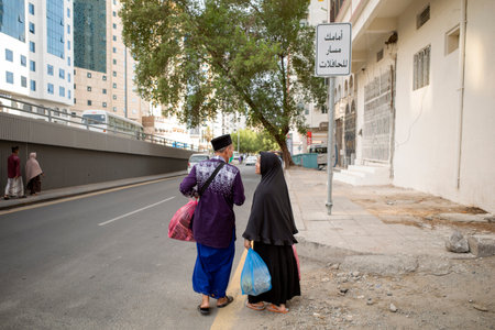 Mecca, Saudi Arabia - June 12, 2024: A couple of Indonesian Hajj and Umrah pilgrims walking after buy some gifts in Makkah, Saudi Arabia. Hajj 2024.のeditorial素材