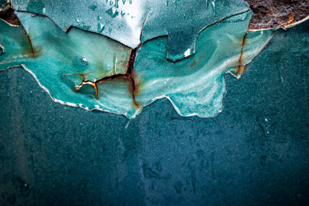Corrosion on exterior part of an old rusty green car.