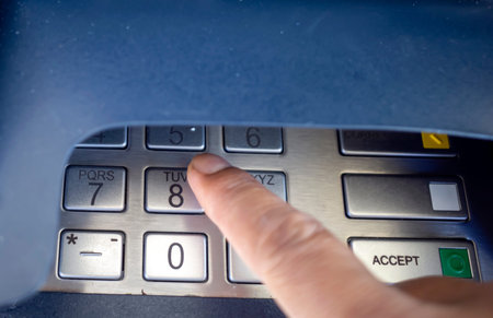 Close up view of a finger pressing number keys on Automated Teller Machine or ATM machine.