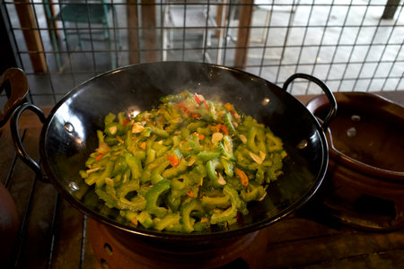 Oseng Pare, stir-fried bitter melon or stir-fried bitter gourd on a black pan, traditional food from Java Island, Indonesia.の写真素材