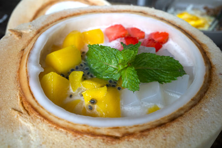 Close up of a mixed fruit salad, colorful dessert in half a fresh coconut.の写真素材