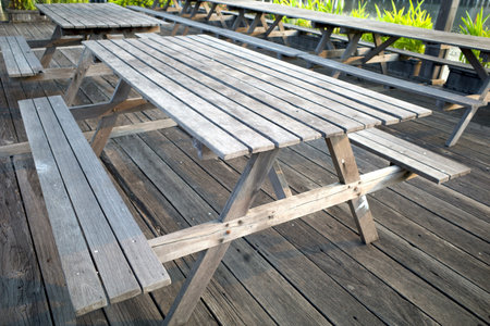An old wooden folding table, on a wooden floor in a garden.