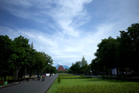 Yogyakarta, Indonesia - December 9, 2024: boulevard front gate with Merapi mountain and bluesky in...