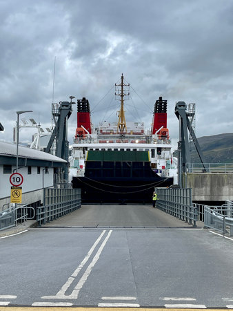 Large car and passenger ferry docked at port terminal ramp ready for loading