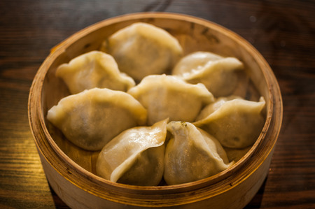Close up to a bamboo basket filled with chinese style dumplingsの写真素材