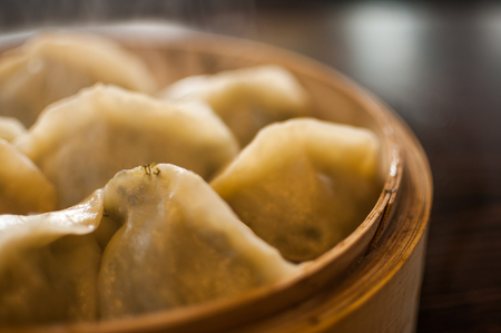 Close up to a bamboo basket filled with chinese style dumplingsの写真素材