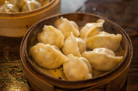 Close up to a bamboo basket filled with chinese style dumplingsの写真素材
