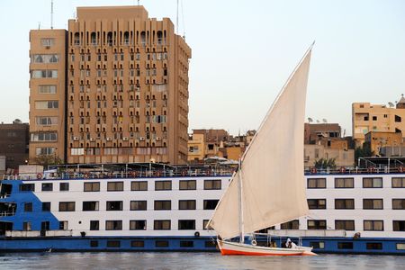 A felucca in front of a tourist boat in Aswanの写真素材