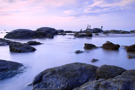 Landscape of sea with dramatic wave and rock in sunset.