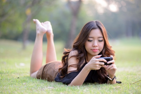 Asia women talking mobile phone in the parkの写真素材