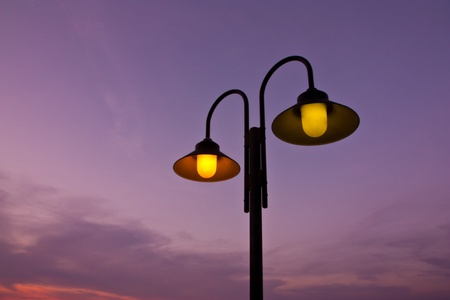The light of a street lamp near the sea at sunsetの写真素材