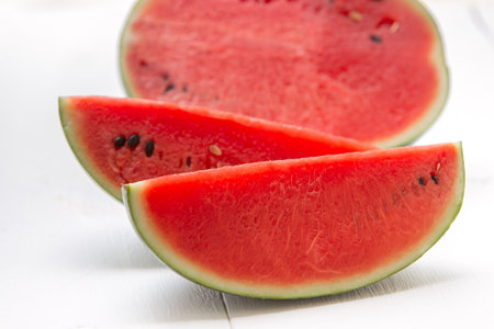 Watermelon cut into pieces on a wooden cutting board placed on the table
