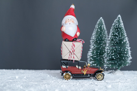 vintage car with gifts and Santa Claus in the snowの写真素材