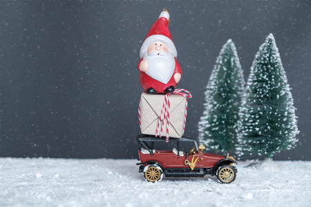 vintage car with gifts and Santa Claus in the snowの写真素材