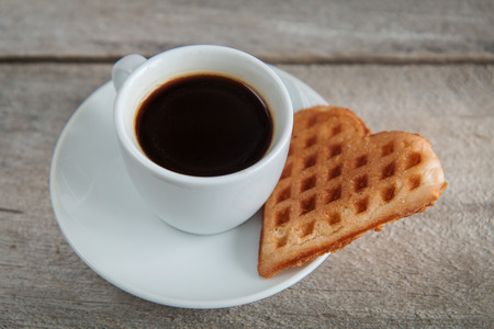 cup of coffee on a wooden table with cookies and candyの写真素材