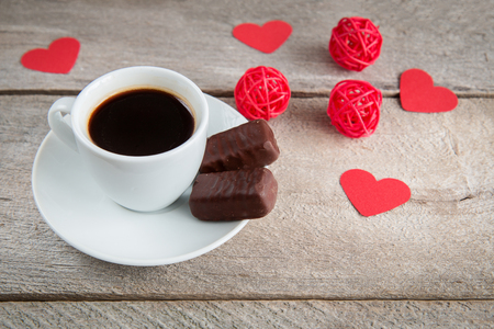 cup of coffee on a wooden table with cookies and candyの写真素材