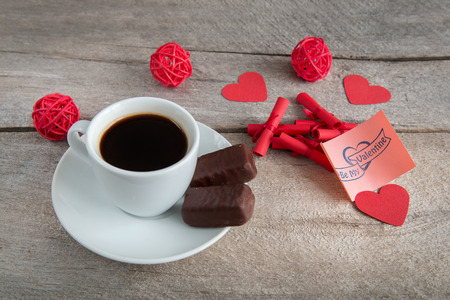 cup of coffee on a wooden table with cookies and candyの写真素材