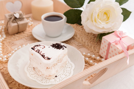 Breakfast coffee and cake with gifts, flowers on the trayの写真素材