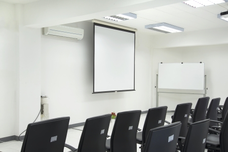 An Empty conference room with blackchairs ,Projection screen and whiteboardの写真素材