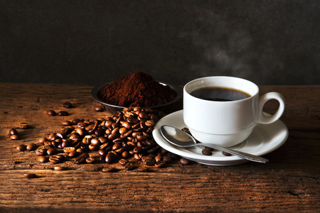 Still life with Hot Coffee in  cup and coffee beans,ground coffee on a wooden table.の写真素材