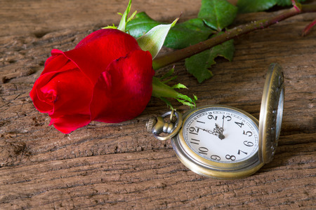 Red roses on wood and antique clockの写真素材