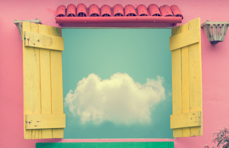 Open window in summer day with cloud on blue sky (vintage color toned image)の写真素材