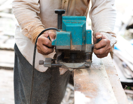 Man carpenter  cutting wood with electric saw, for  Home Building