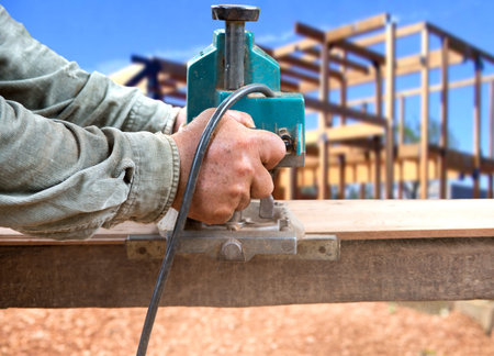 Man carpenter  cutting wood with electric saw, for  Home Building