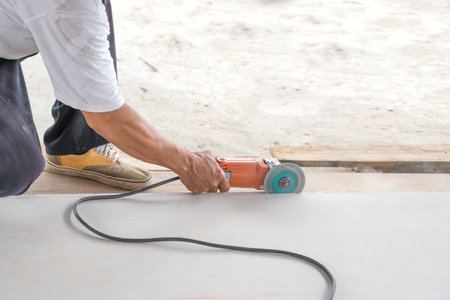 Man construction worker  cutting tile with electric saw hand working, for  Home Building