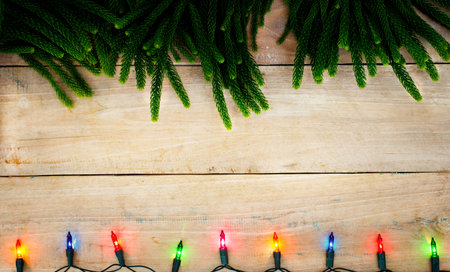 Christmas fir tree with colorful light decoration on wooden board background with copy spaceの写真素材