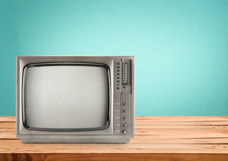 Retro Television on wood table with vintage aquamarine wall backgroundの写真素材