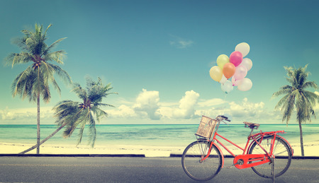 vintage bicycle with balloon on beach blue sky concept of love in summer and wedding honeymoonの写真素材