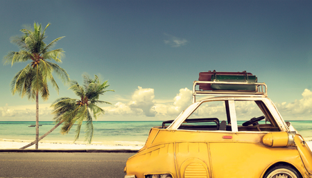 Travel destination: vintage car parked near the beach with bags on a roof - Honeymoon tripの写真素材