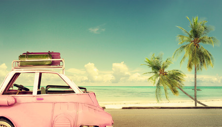 Travel destination: vintage classic car parked near the beach with bags on a roof - Honeymoon trip in summer